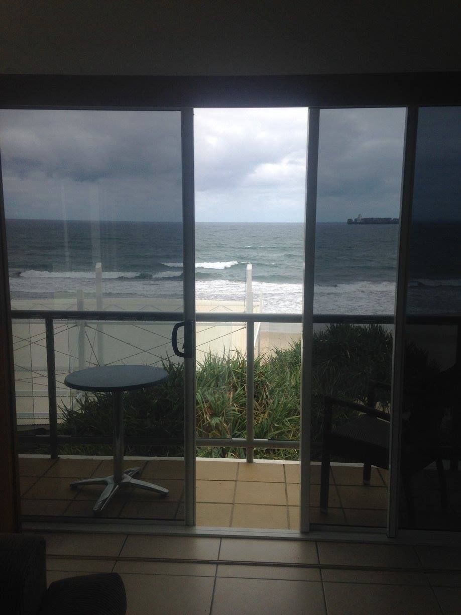 A view of the ocean through a sliding glass door — TSR Tinting & Frosting In Caloundra West, QLD