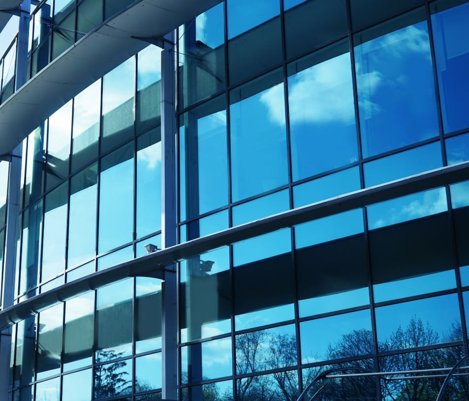 a Building With a Lot of Windows and a Blue Sky Reflected in the Windows — TSR Tinting & Frosting In Caloundra West, QLD