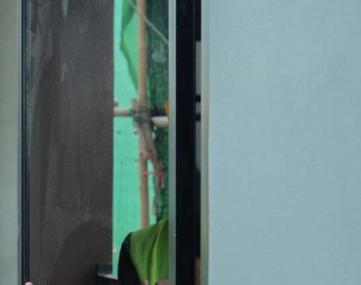 A Person is Standing in a Room Looking Out of a Window — TSR Tinting & Frosting in Noosa, QLD