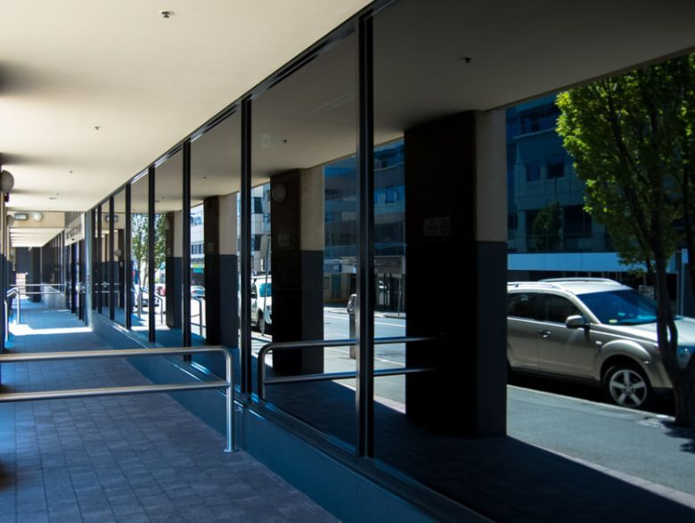 A Car is Parked on the Side of the Road in Front of a Building — TSR Tinting & Frosting in Caloundra, QLD