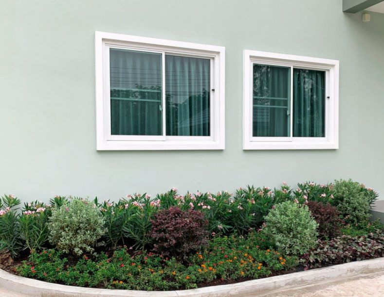A House With Two Windows and a Garden in Front of It — TSR Tinting & Frosting in Maroochydore, QLD