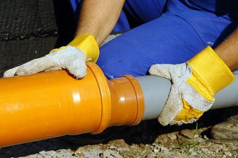 Hand Holding Pipes — Martinez, CA — Ernie’s Plumbing & Sewer Service