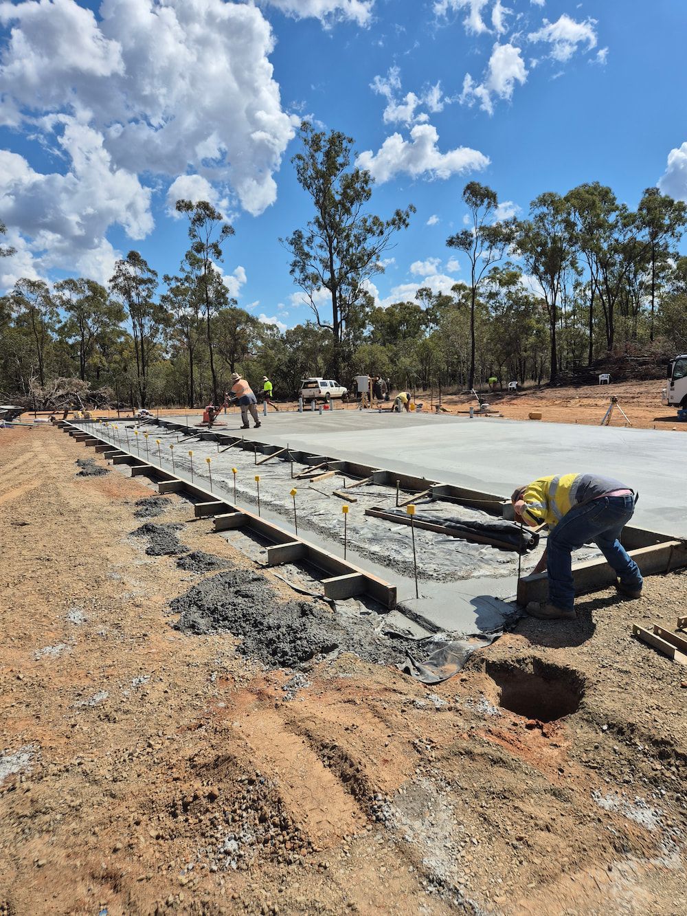 Workers Pouring and Leveling Concrete for a Roadside Slab — TP Concreting In Figtree, NSW