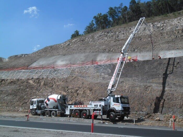 A Cement Mixer And A Concrete Pump Are On The Side Of A Road — TP Concreting In Warilla, NSW