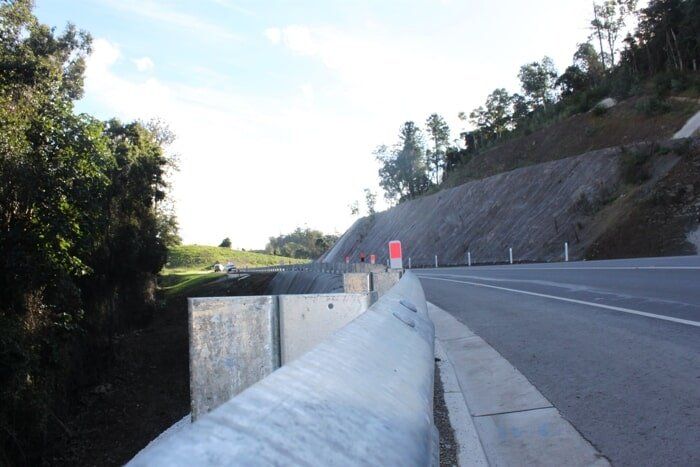 A Road With A Concrete Barrier On The Side Of It — TP Concreting In Figtree, NSW