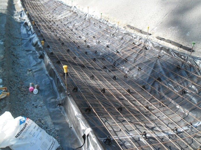 A Bag Of Technan Is Sitting On The Ground Next To A Piece Of Concrete — TP Concreting In Warilla, NSW