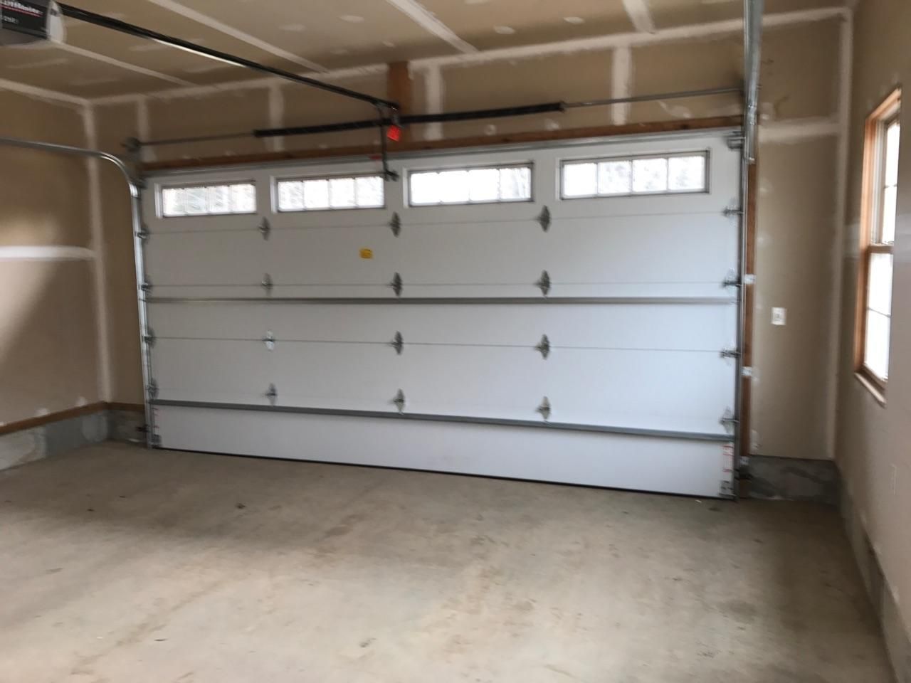 An empty garage with a large white garage door