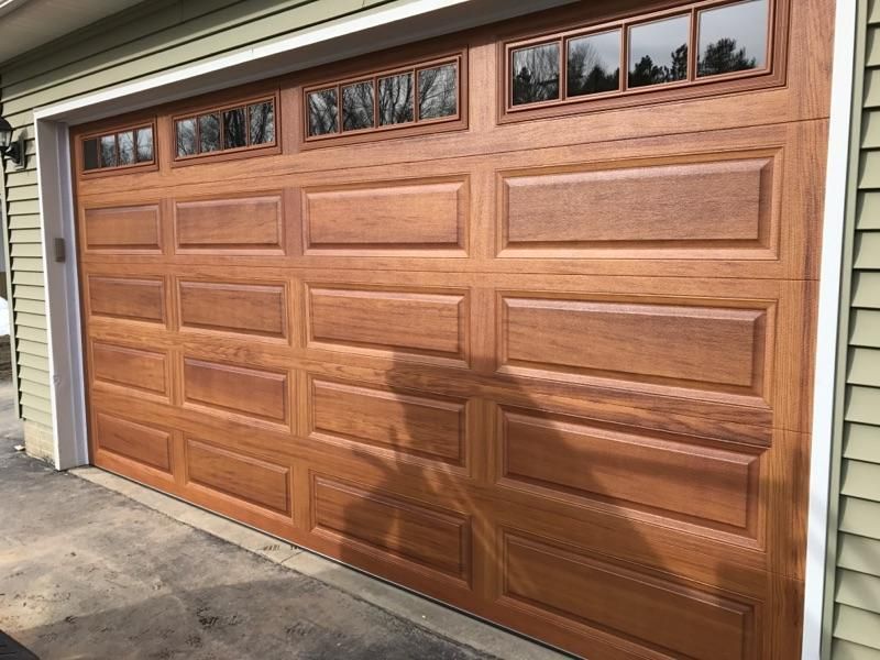 The garage door is made of wood and has a lot of windows.