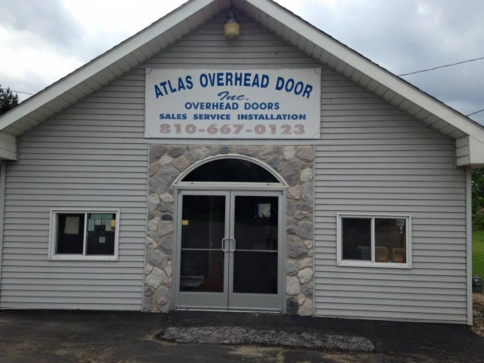 Two wooden garage doors are sitting next to each other on the side of a building.
