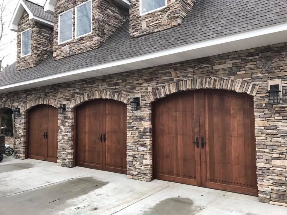 A row of wooden garage doors on a stone building.