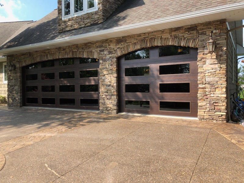 A large garage door is sitting in front of a stone building.