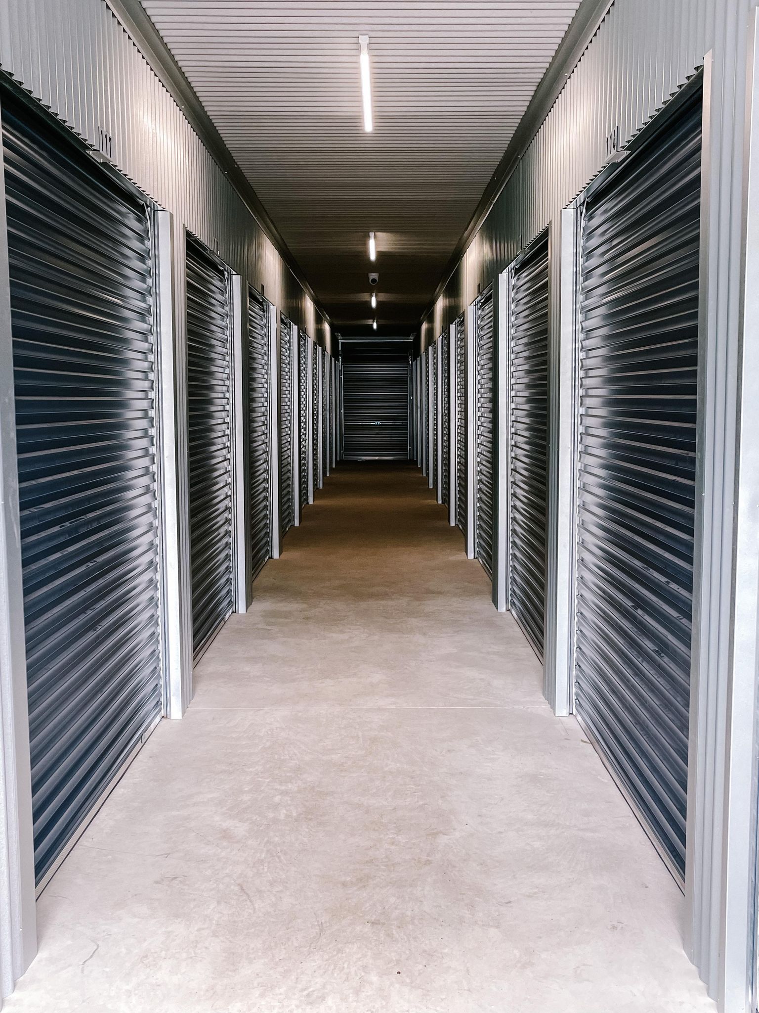 A long hallway filled with rows of garage doors.
