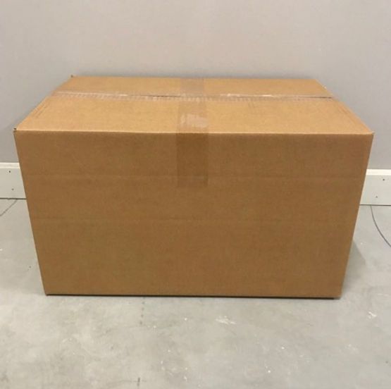 A cardboard box is sitting on a concrete floor.