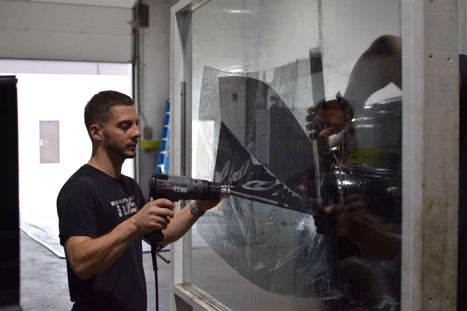 A man is applying window tinting to a window.