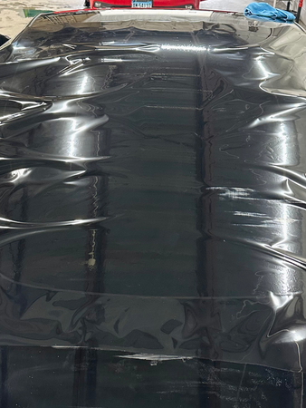 The roof of a car is covered in black plastic.