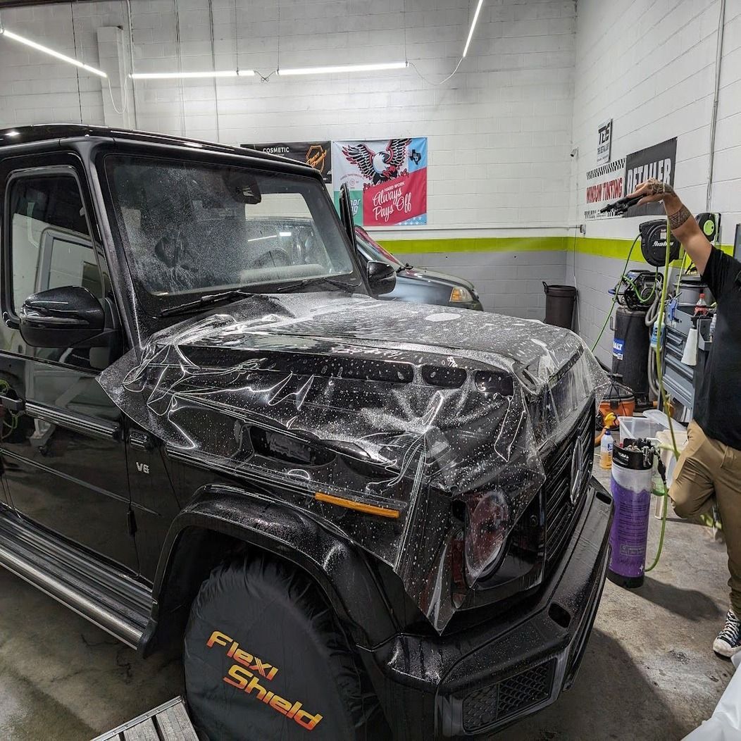 A red car is parked on the side of the road