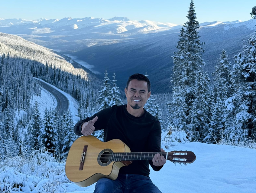 Man in mariachi outfit playing a trumpet; close up of the instrument.