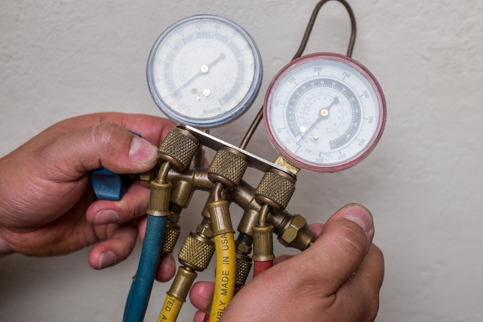 A person is holding a pressure gauge in their hands.