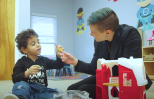 A woman is playing with a little boy in a room.