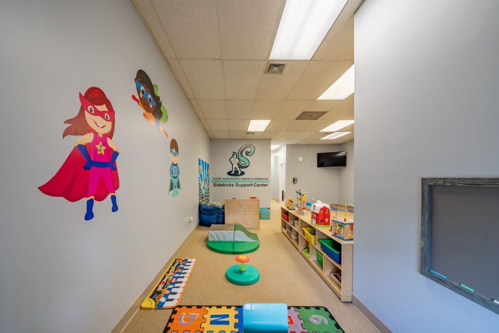 A child 's room with a superhero painting on the wall.