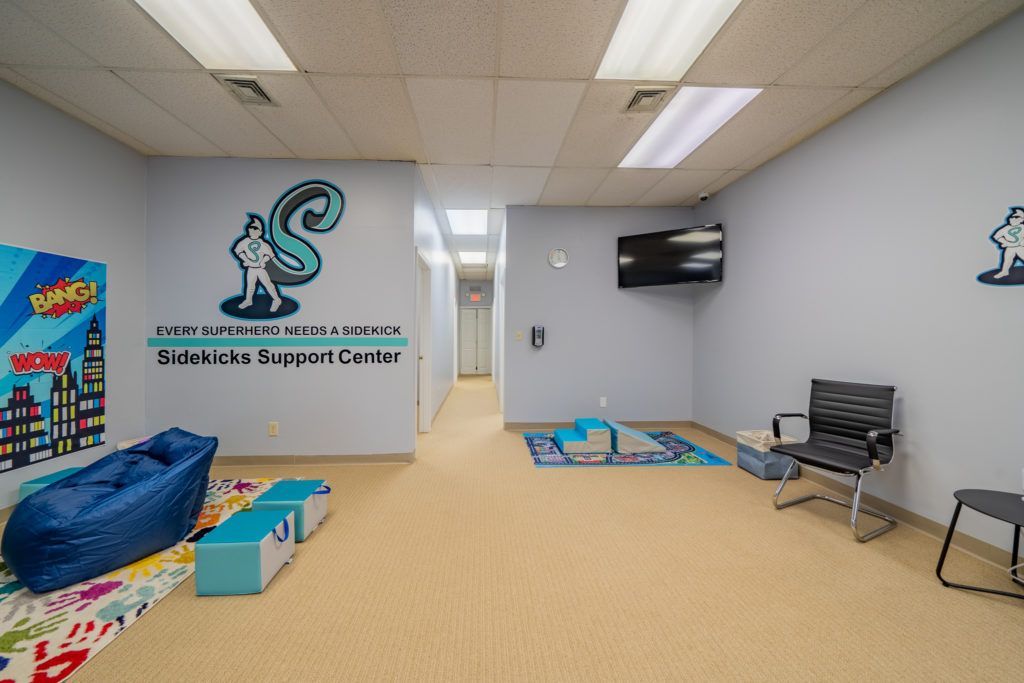 A waiting room with a blue bean bag chair and a tv on the wall.