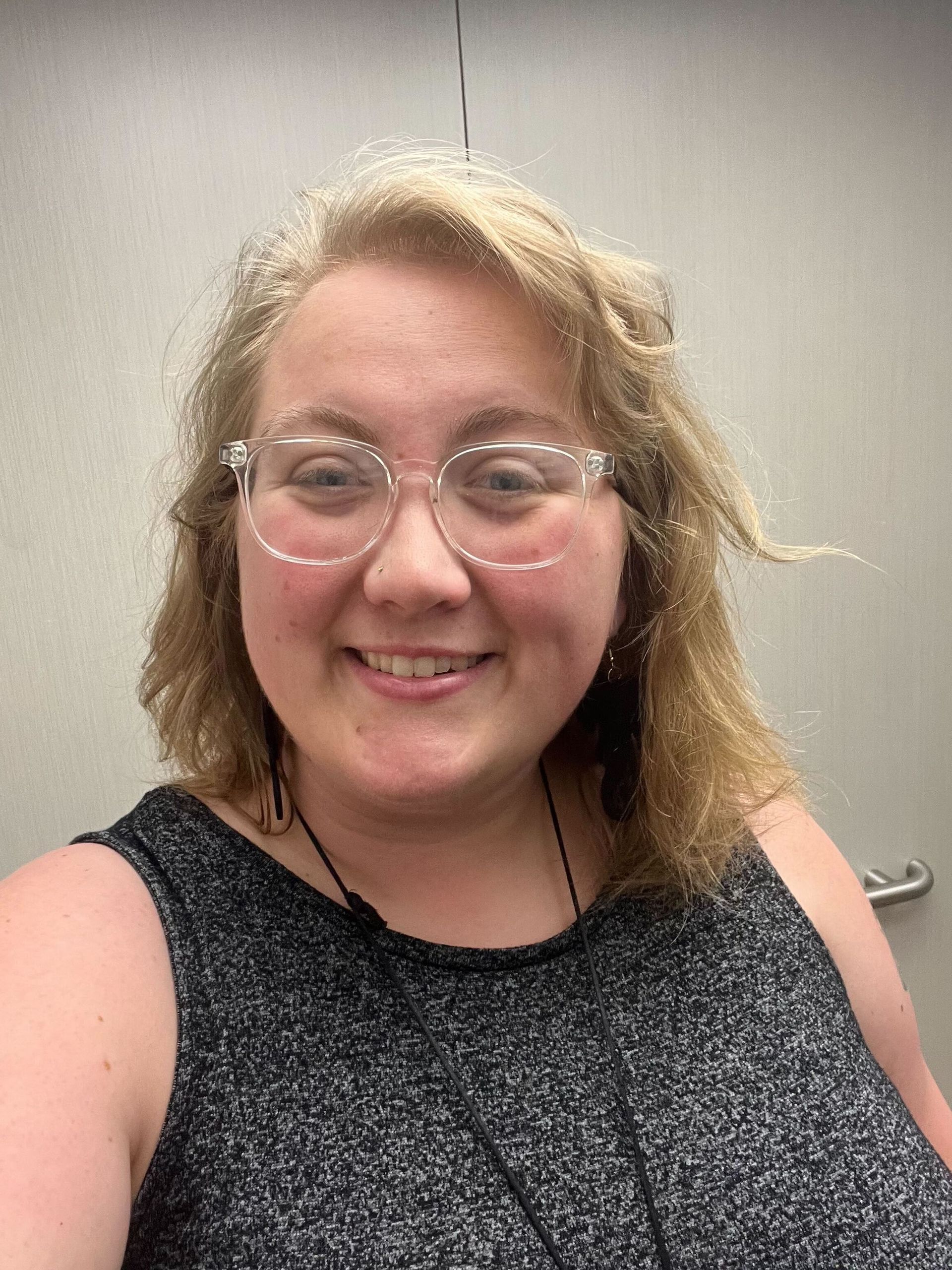 A woman with a bun on her head is smiling for the camera