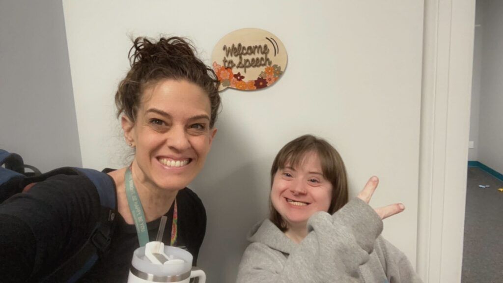 A woman and a girl are standing next to each other in front of a door.