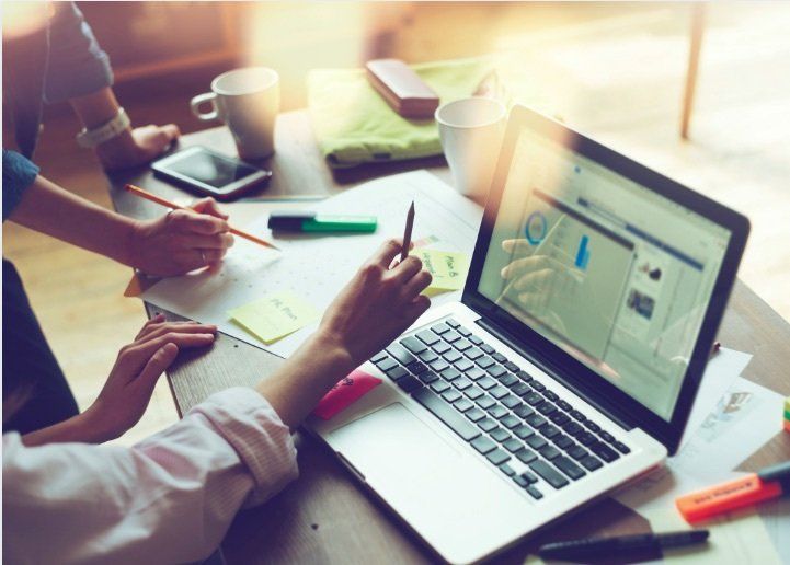 A strategy session on the laptop, with highlighters and sticky notes on the desk