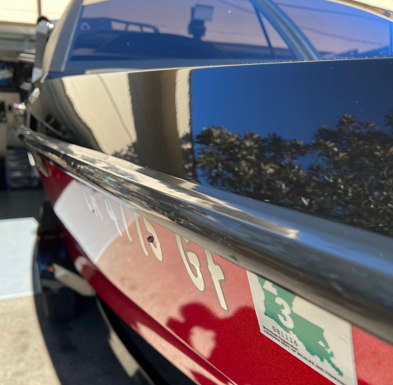 Ceramic Coating - A man is polishing a boat with a machine .