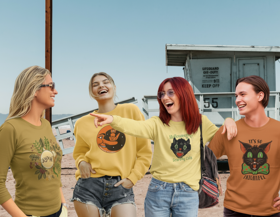 Four people on a beach wearing Halloween-themed shirts and laughing near a lifeguard tower.