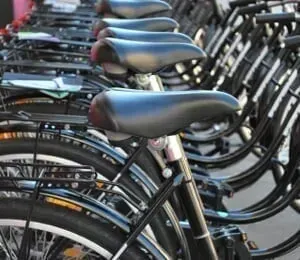 A row of bicycles are lined up in a parking lot.