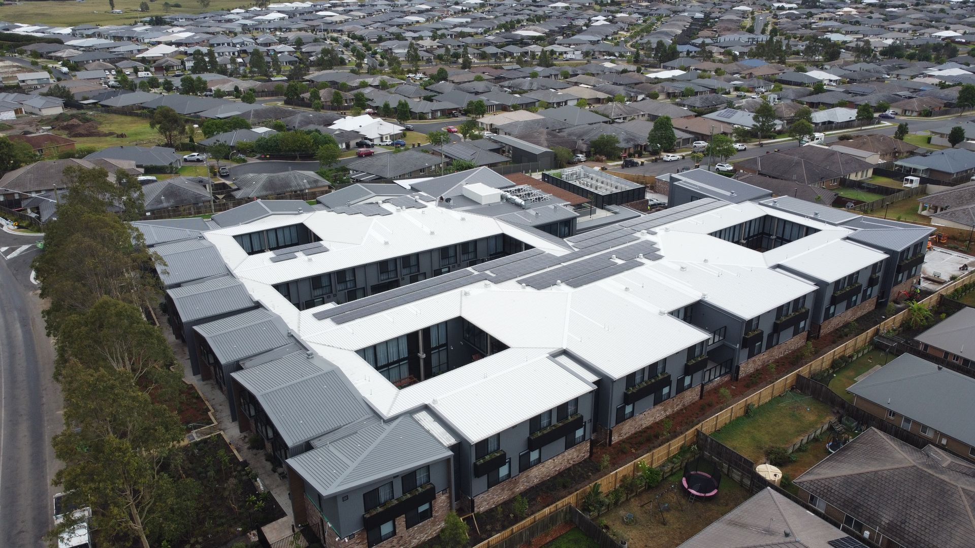 A row of apartment buildings with a car parked in front of them.