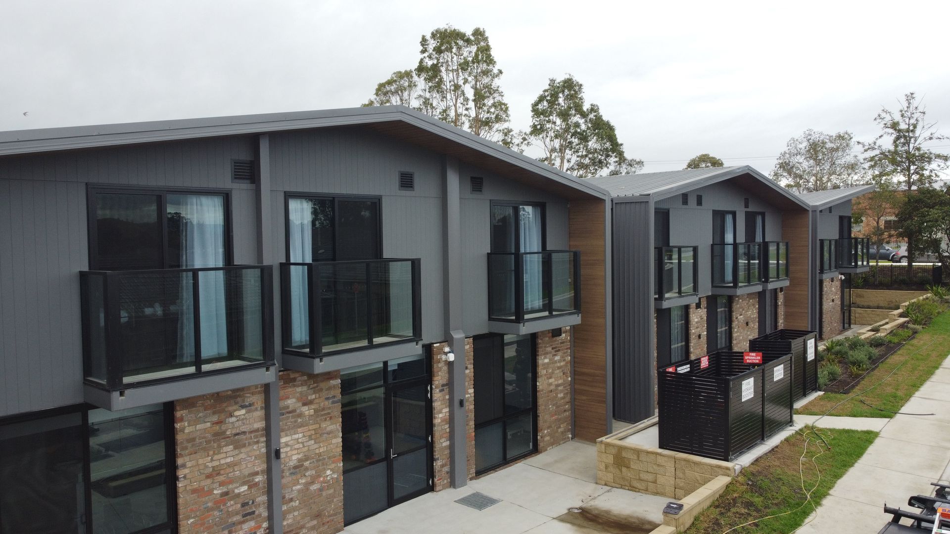 A row of apartment buildings with balconies and sliding glass doors.