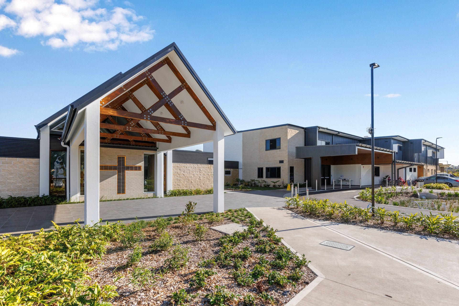 A large building with a wooden roof and a cross on the side of it.