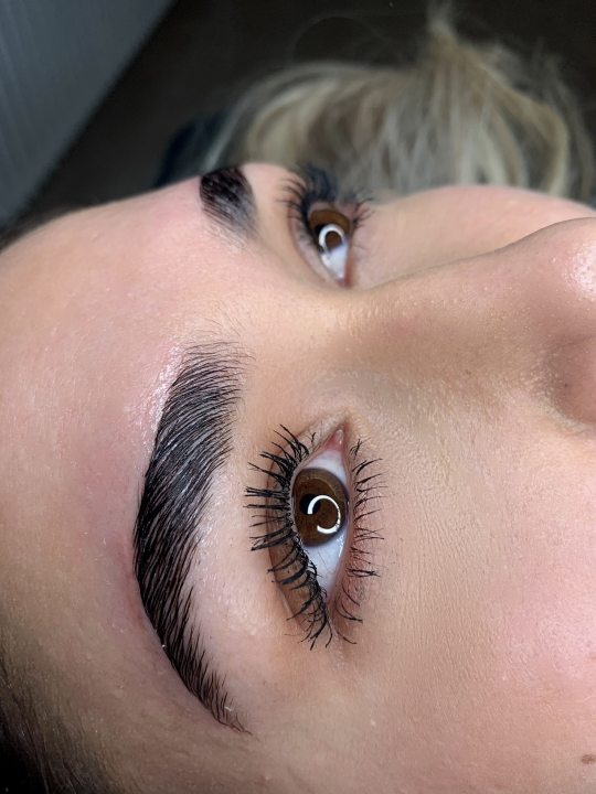 Eine Nahaufnahme des Gesichts einer Frau mit langen Wimpern und Augenbrauen.