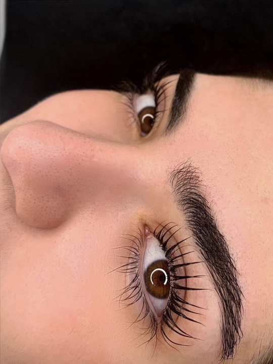 Eine Nahaufnahme des Gesichts einer Frau mit langen Wimpern und Augenbrauen.