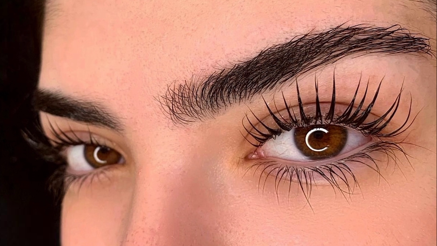 Eine Nahaufnahme des Auges einer Frau mit langen Wimpern.