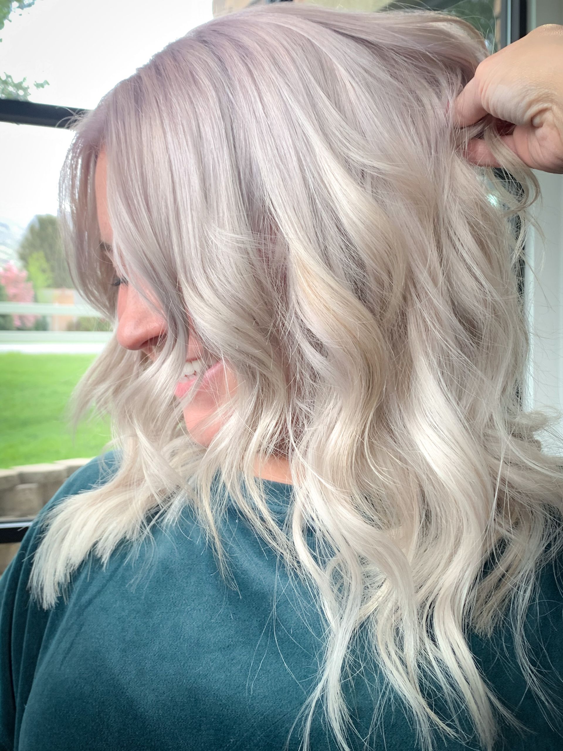 A woman with blonde hair is getting her hair done by a hairdresser.