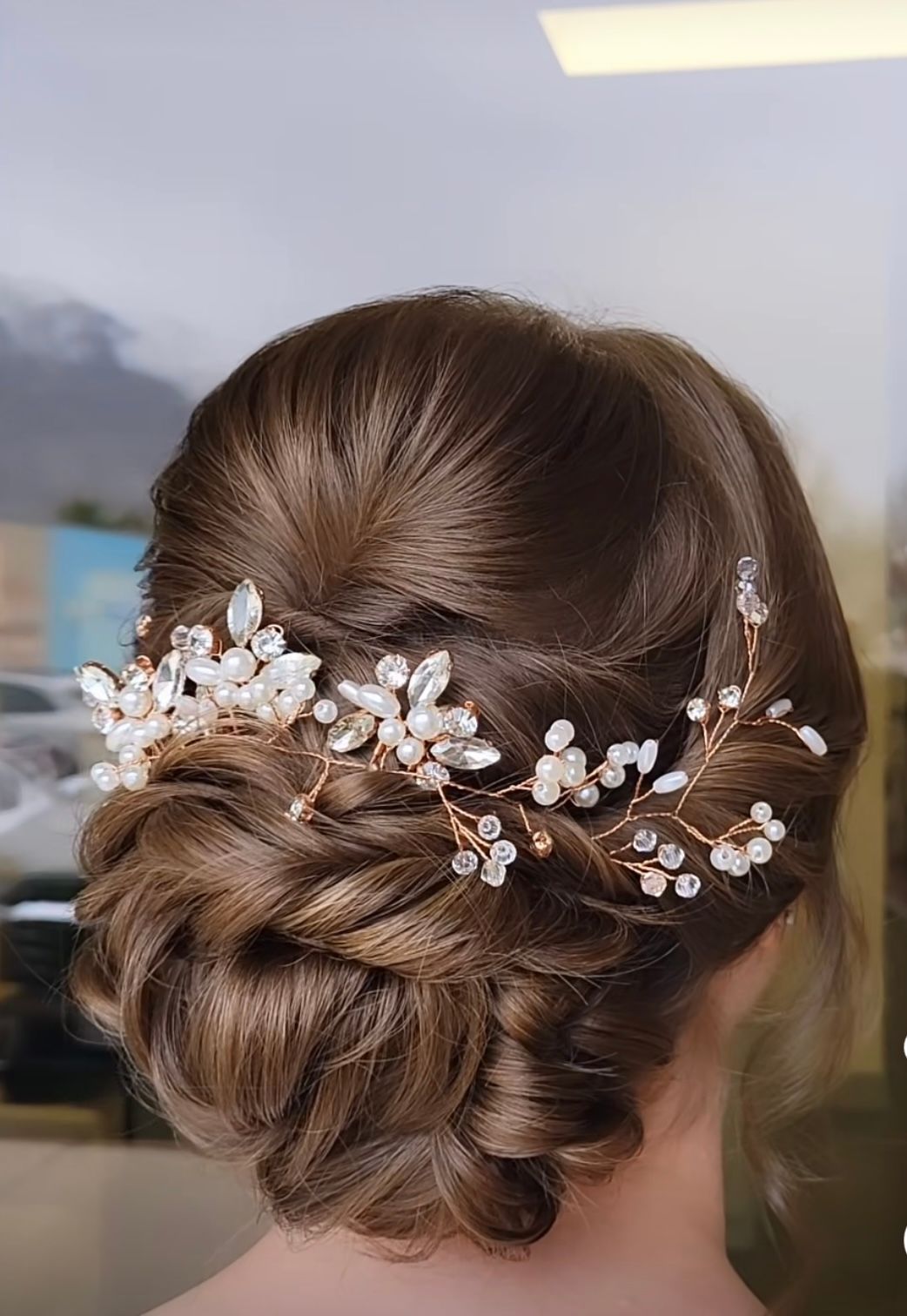 A woman is wearing a bun with a headpiece in her hair.