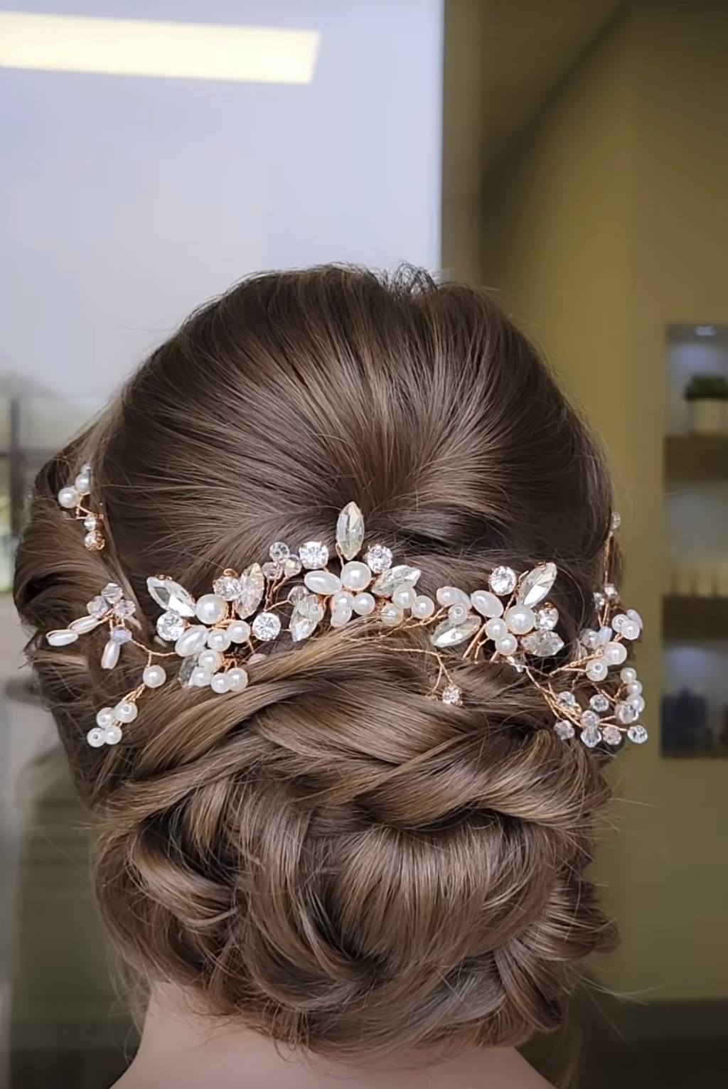 The back of a woman 's head with a bun and a headpiece.
