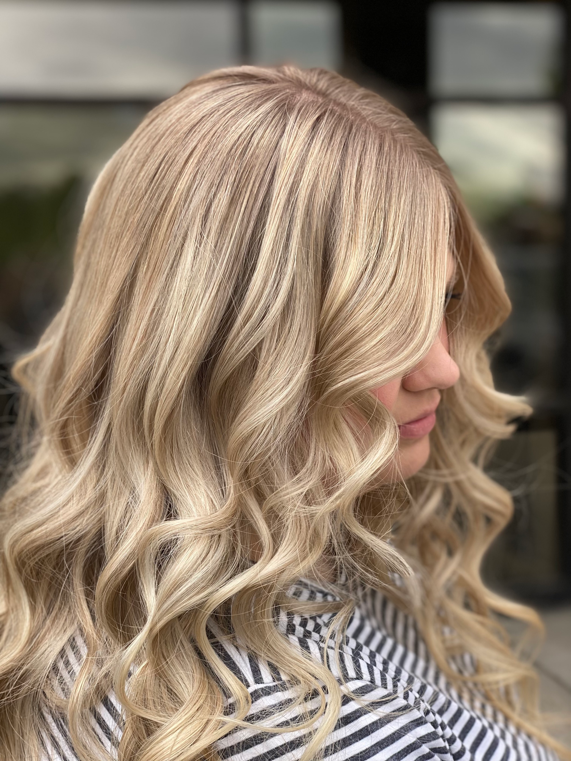 A woman with long blonde hair is wearing a striped shirt.