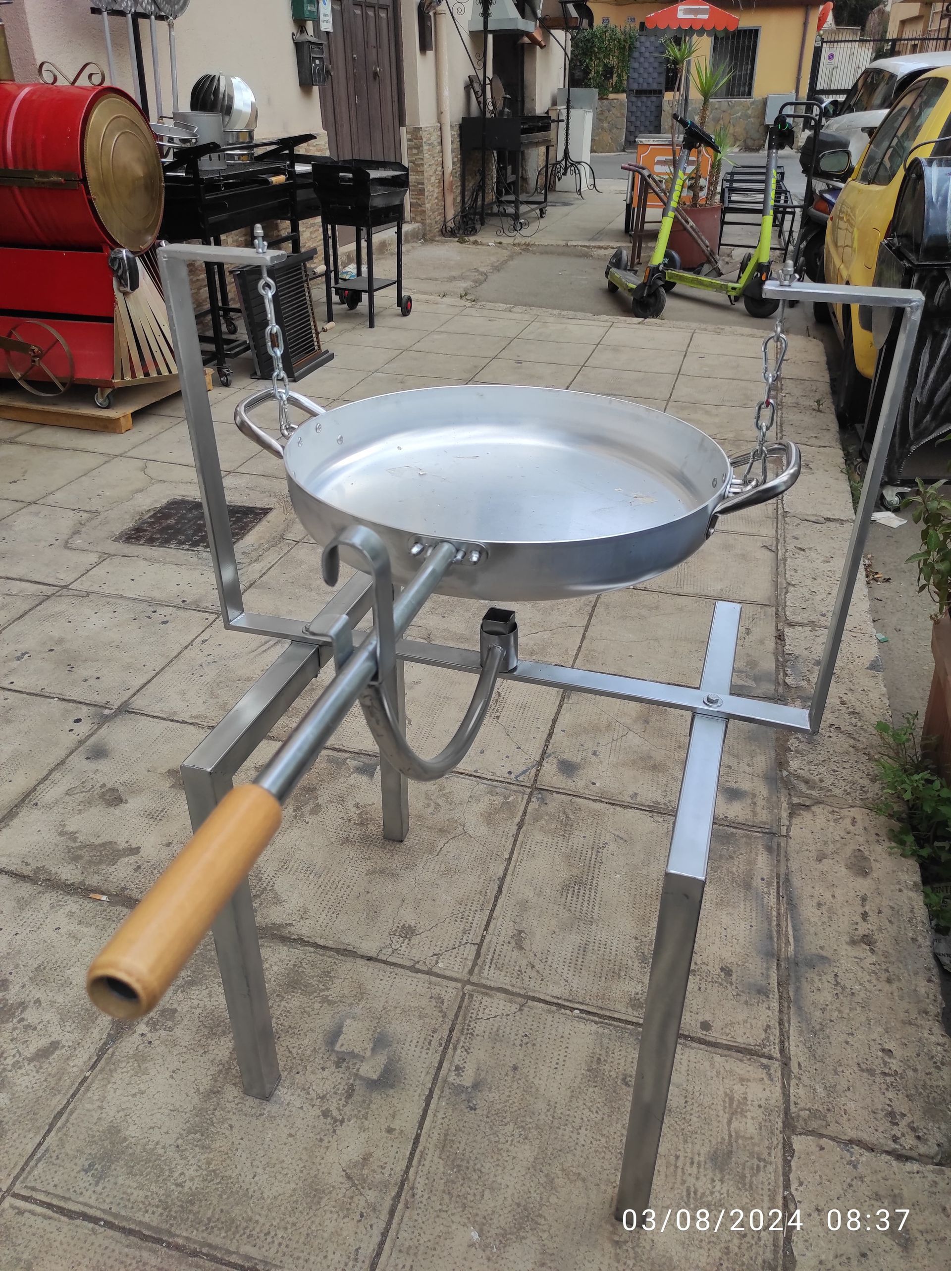 Padella per paella in metallo su supporto, manico con impugnatura in legno, per esterni su piastrelle.