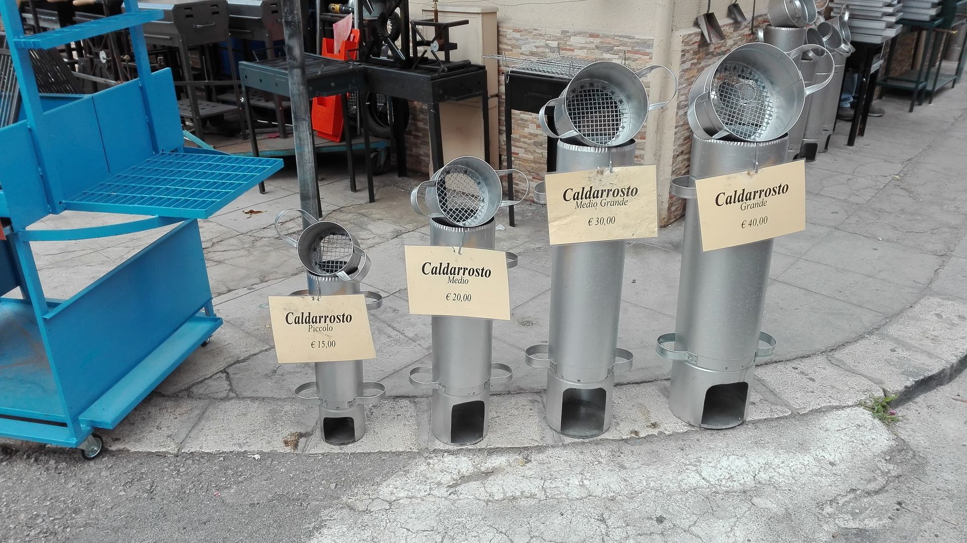 Quattro stufe a razzo in metallo di varie dimensioni, con tanto di cartellino del prezzo, all'esterno, su un marciapiede.