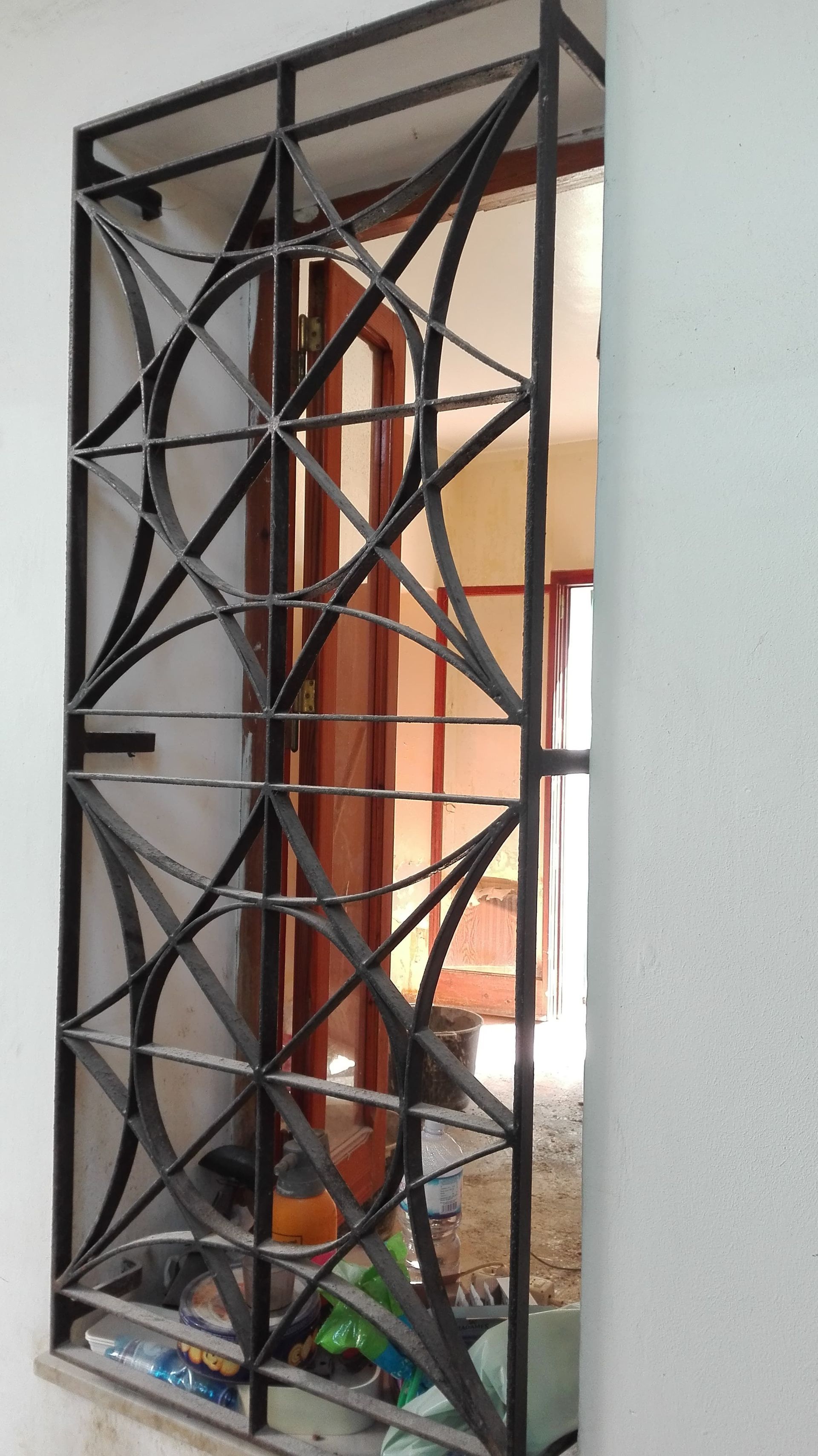 Barre di sicurezza in metallo nero per finestre con un intricato disegno geometrico.