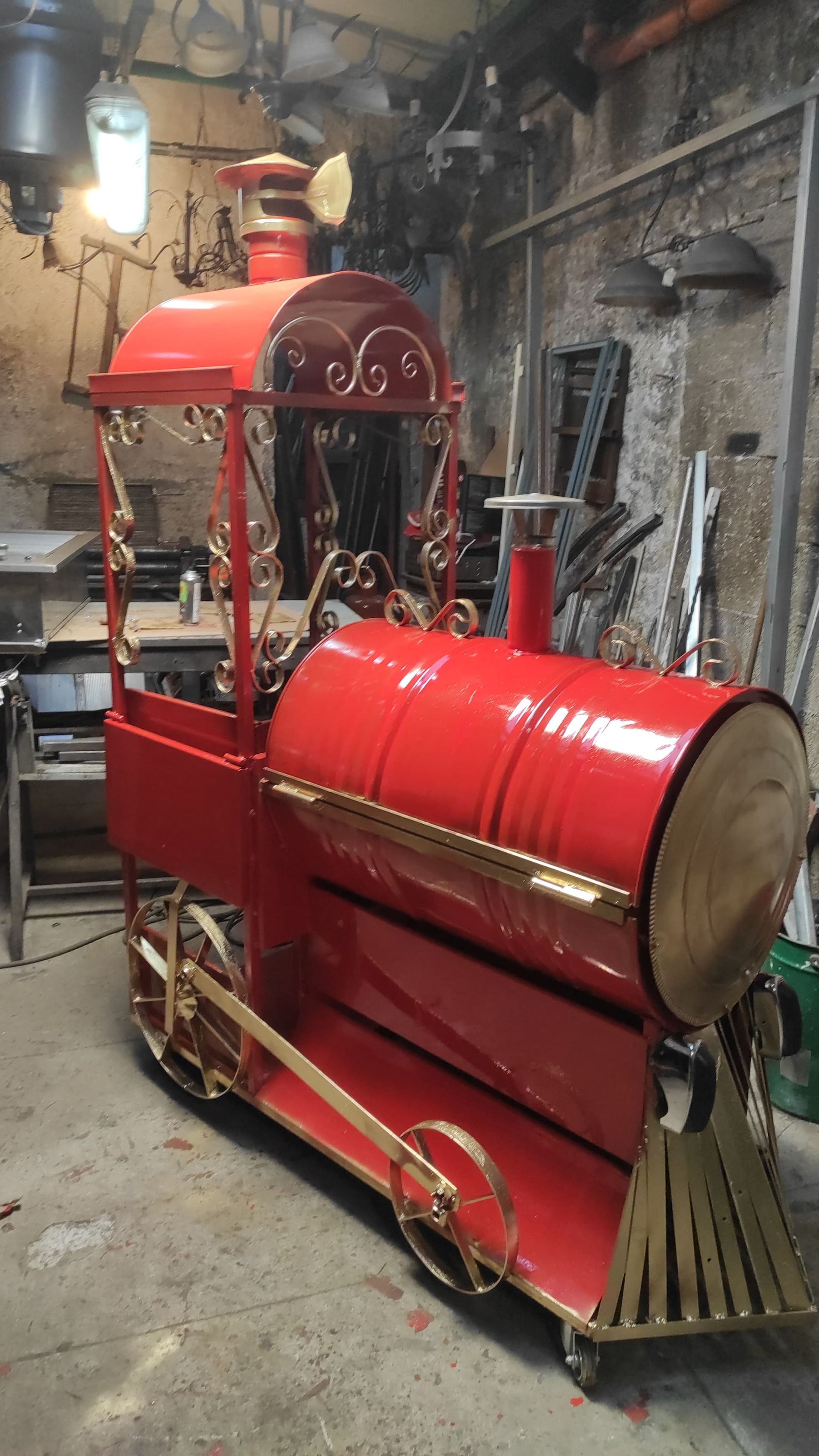 Scultura di un treno in metallo rosso e oro in un laboratorio.