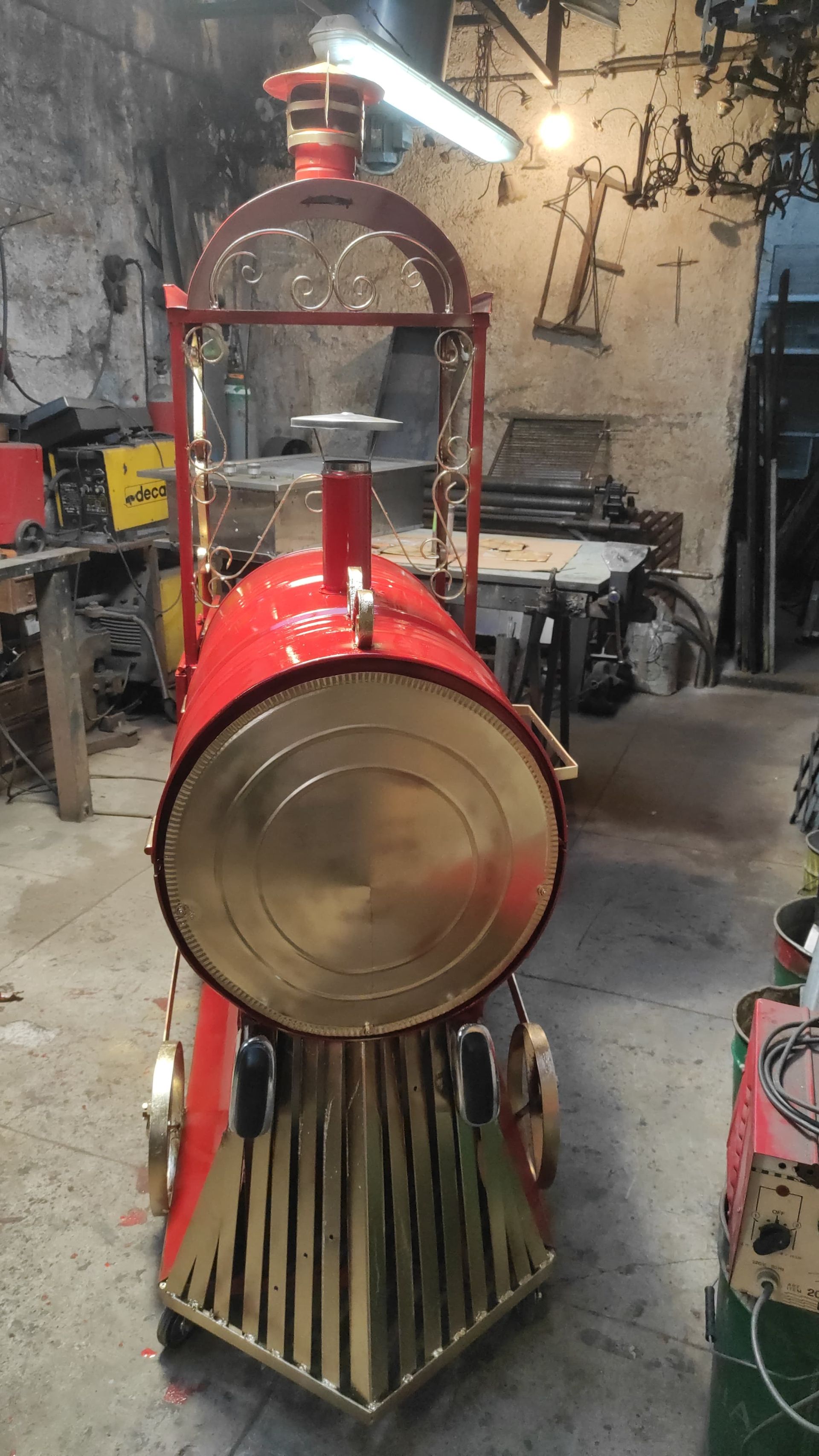 Trenino giocattolo rosso e oro ambientato in un laboratorio.