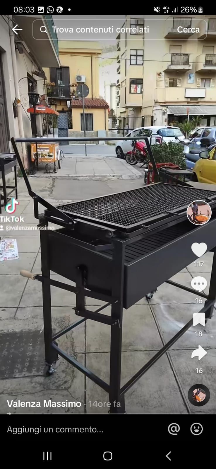 Griglia metallica nera su un marciapiede con edifici e automobili sullo sfondo.