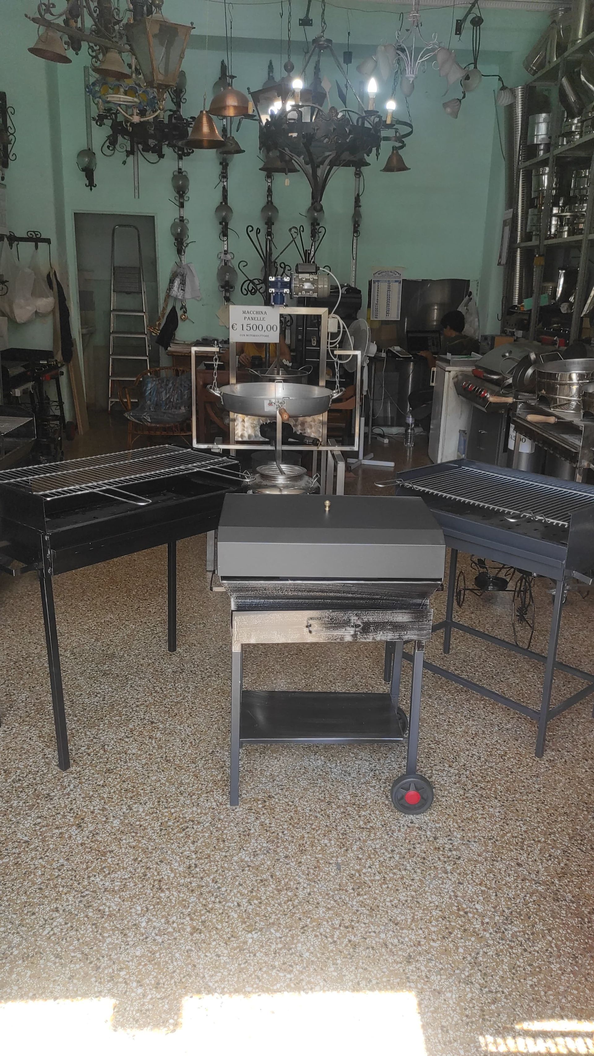 Un negozio pieno di attrezzature da cucina, tra cui griglie e vari utensili da cucina appesi.