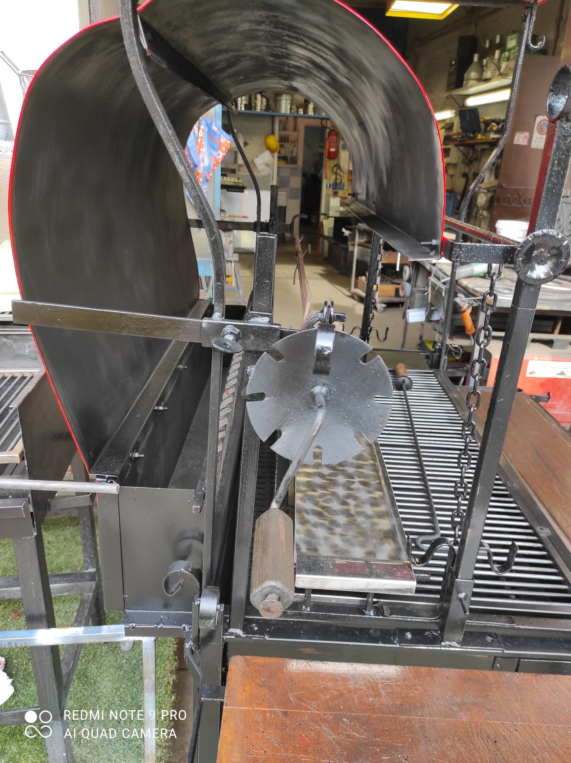 Griglia girarrosto in metallo nero con parte superiore curva.