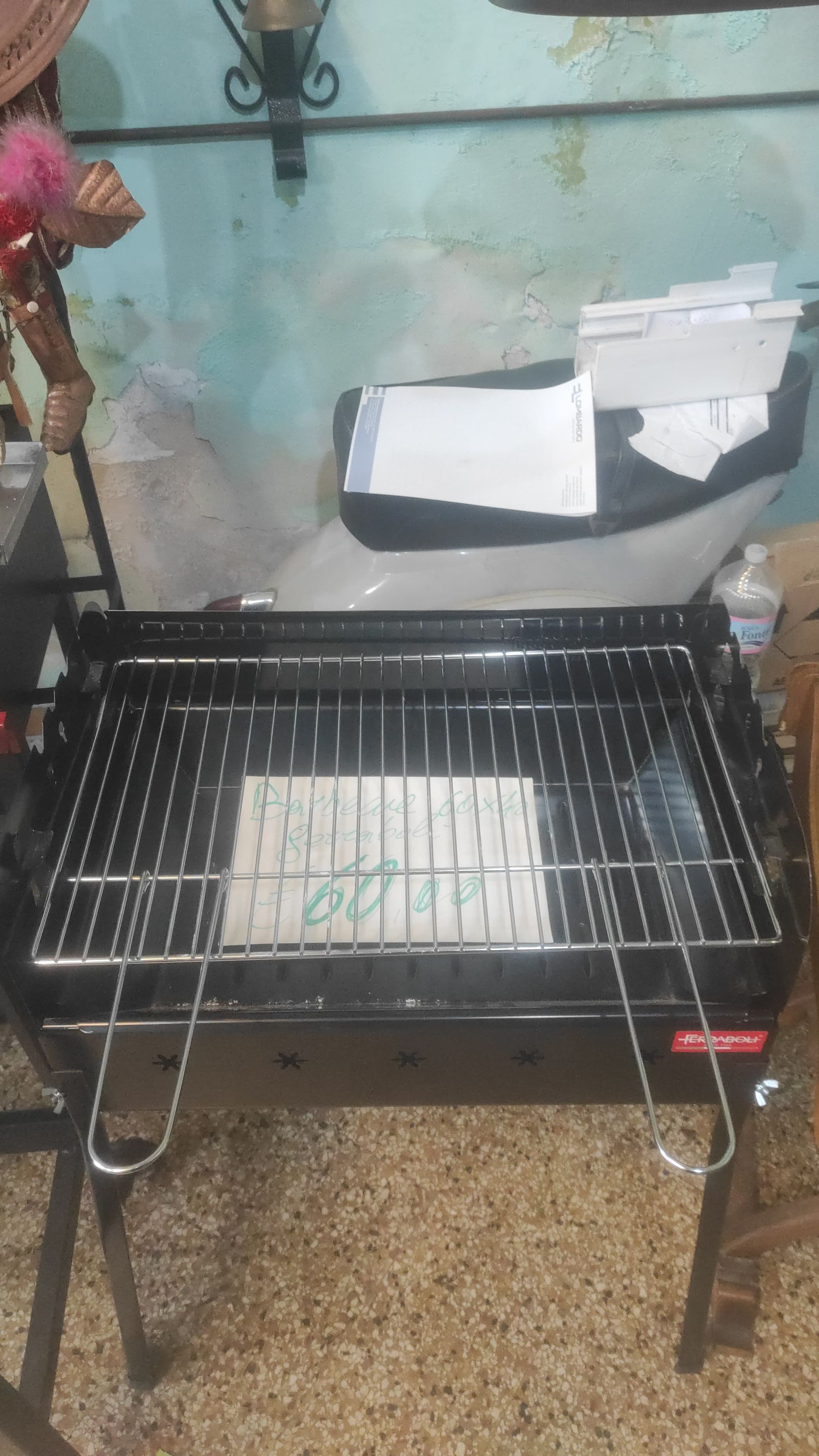 Barbecue a carbone nero con barre cromate e gambe pieghevoli, per esterni.